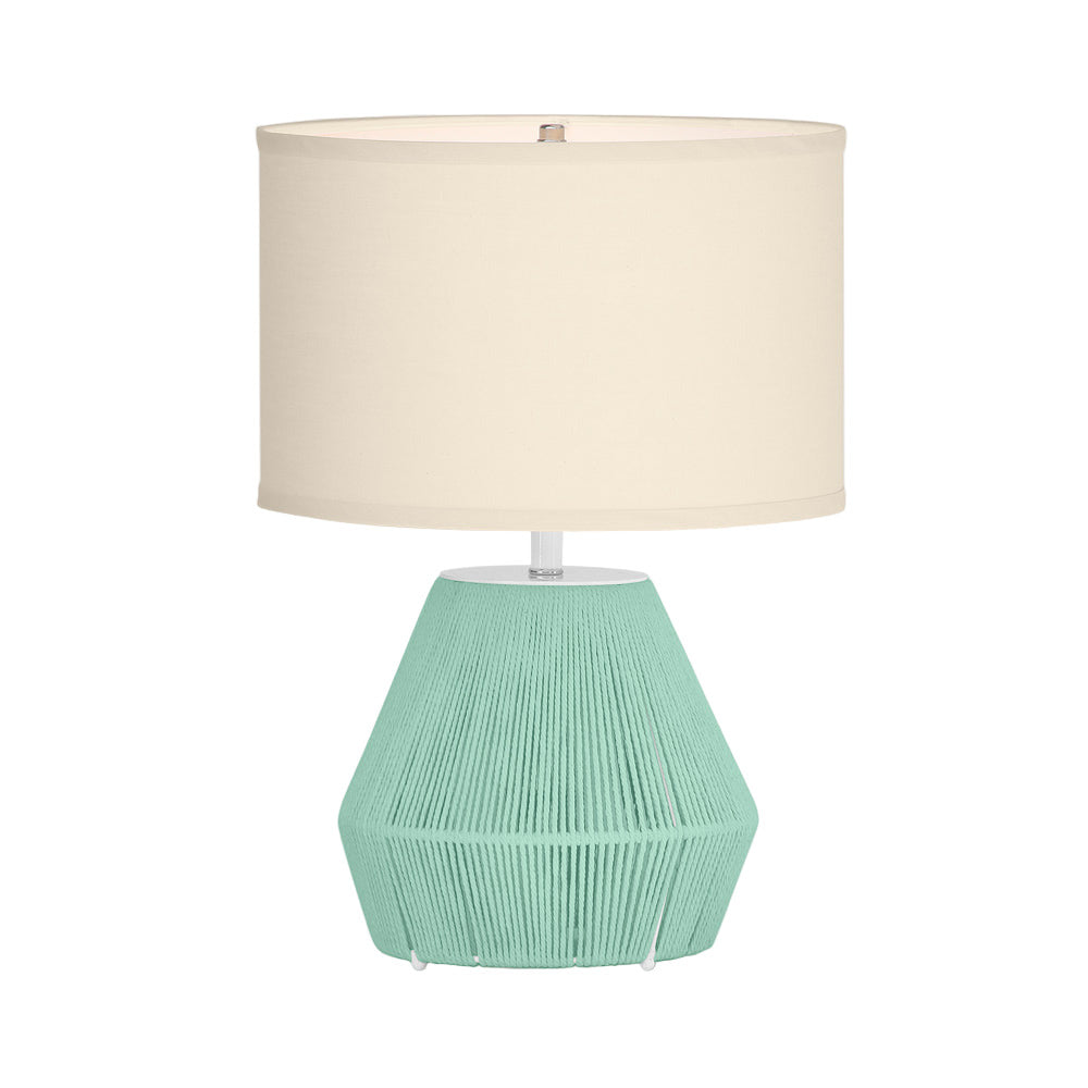 Table lamp with a textured green base and beige shade on a white background