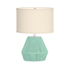 Table lamp with a textured green base and beige shade on a white background